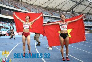 Nguyễn Thị Oanh (trái) và Hồng Lệ giương cao lá cờ Việt Nam sau khi lần lượt về nhất và nhì ở nội dung 10.000m nữ. Ảnh: Hiếu Lương